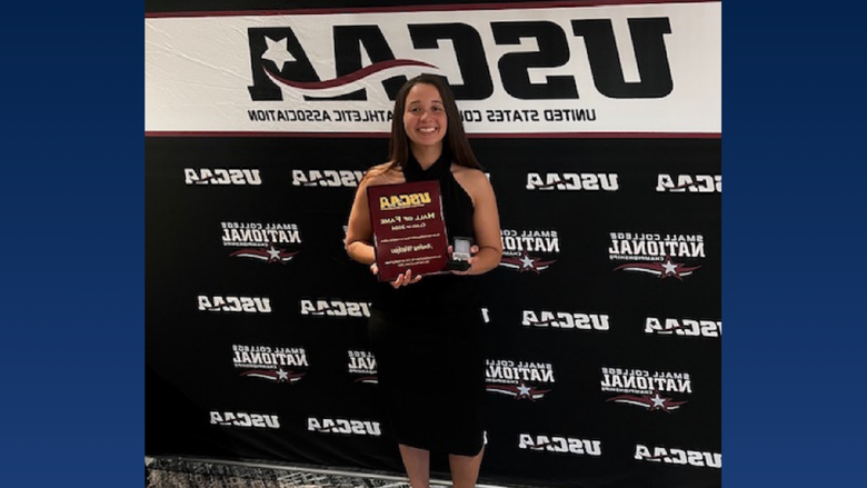 A college student holding an award