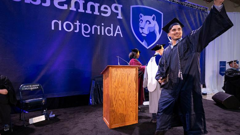 Student waves after accepting bachelor's degree